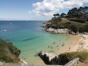 eine Gruppe von Menschen im Wasser an einem Strand in der Unterkunft Appartement rénové avec vue mer au Palais, proche commerces - FR-1-418-175 in Le Palais