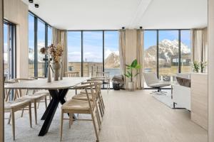 a dining room with a table and chairs and mountains at Lyngvær Sunrise Lodge - Hot tub - No 11 in Storøya