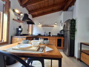 a kitchen with a wooden table with wine glasses at Joli Apartments - Studio 12 in San Martín de los Andes