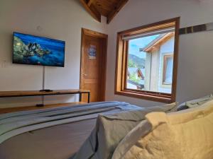 a bedroom with a bed and a large window at Joli Apartments - Studio 12 in San Martín de los Andes