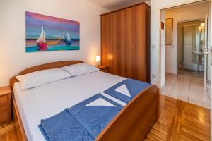 a bedroom with a bed with a painting on the wall at Biserka 2 with stunning sea view in Punat