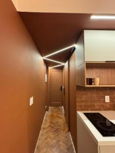 a small kitchen with a hallway leading to a door at Studio Terra in Rio de Janeiro