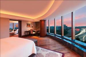 a hotel room with a view of the city at The Leela Ambience Gurugram Hotel & Residences - The Luxury Urban Sanctuary in Gurgaon