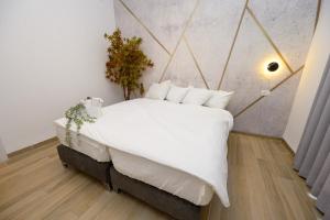 a bedroom with a large white bed with white pillows at מלון סול in Tiberias