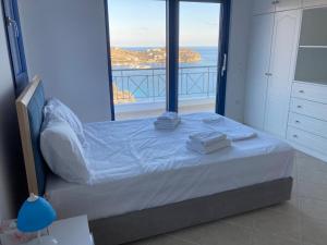 a bedroom with a bed with a view of the ocean at Archontiko Dagmar in Áyioi Apóstoloi +32 photos