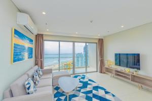 a living room with a couch and a large window at Apartment Galaxy The Song Vung Tau Homestay in Vung Tau