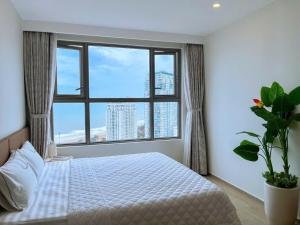 a bedroom with a bed and a large window at Apartment Galaxy The Song Vung Tau Homestay in Vung Tau
