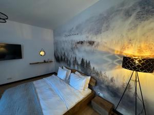 a bedroom with a bed with a painting on the wall at Zen Retreat Apartment in Sinaia