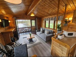 una sala de estar con un sofá y una mesa en Hickling Broads Lodge Houseboat, en Stalham
