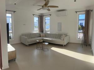 Una sala de estar con un sofá y un ventilador de techo. en The luxury flamingo, en Willemstad