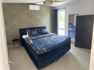Una cama azul en una habitación con espejo. en The luxury flamingo, en Willemstad 30 fotos más