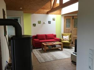 Una sala de estar con un sofá rojo y una mesa de café. en Ferienwohnung Turmblick, en Marienrachdorf