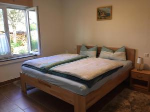 una cama en una habitación con ventana en Ferienwohnung Turmblick, en Marienrachdorf