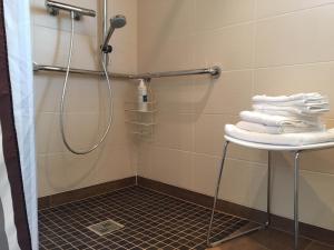 y baño con ducha y una pila de toallas. en Ferienwohnung Turmblick, en Marienrachdorf 12 fotos más