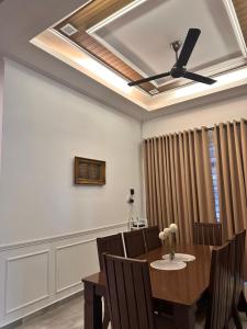 a dining room with a table and a ceiling fan at Homestay Husna in Dungun