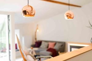 a living room with three lights hanging from the ceiling at Studio EINS in Oersberg