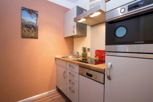 une petite cuisine avec un évier et un réfrigérateur dans l'établissement ancora Marina Haus 2 Nr 02, Typ 2, à Neustadt in Holstein 17 autres photos