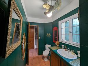 キュエールにあるLa maison sur demandeの緑豊かなバスルーム(シンク、鏡付) +10枚の写真