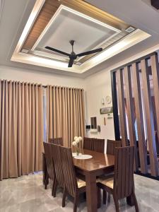 a dining room table with chairs and a ceiling fan at Homestay Husna in Dungun