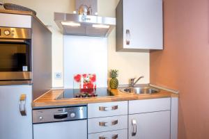 une petite cuisine avec des armoires blanches et un évier dans l'établissement ancora Marina Haus 2 Nr 02, Typ 2, à Neustadt in Holstein