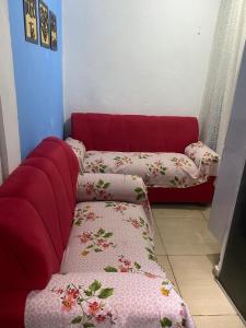 - un canapé rouge avec des oreillers dans l'établissement Kitnet Diamantina, à Diamantina