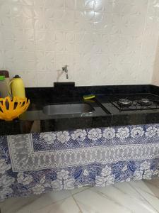 un comptoir de cuisine avec un évier et une cuisinière dans l'établissement Kitnet Diamantina, à Diamantina