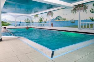 a large swimming pool with a painting on the wall at Ostseehotel Villen im Park - ein Rovell Hotel in Bansin