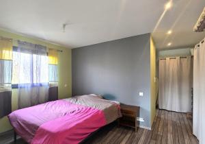 a bedroom with a pink bed and a window at la belle de volnay in Volnay