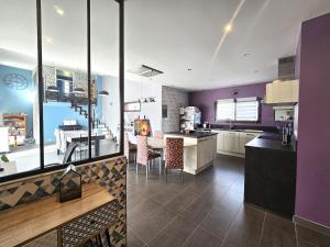 a kitchen with purple walls and a kitchen with a table at la belle de volnay in Volnay