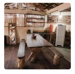 a large wooden table and bench in a room at Igapeba Hospedaria em Moreré in Cairu