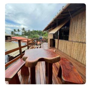 a wooden table on the deck of a building at Igapeba Hospedaria em Moreré in Cairu
