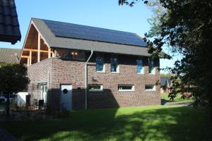 a brick building with solar panels on the roof at FerienhausPenthouse Captain's Bridge in Pellworm