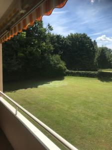 a window view of a large yard from a house at Ferienwohnung am Kurpark Mettnau in Radolfzell am Bodensee