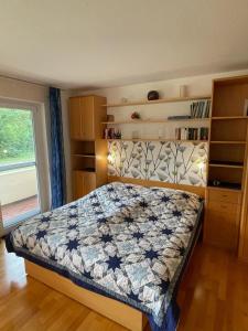 a bedroom with a bed with a quilt on it at Ferienwohnung am Kurpark Mettnau in Radolfzell am Bodensee +7 photos