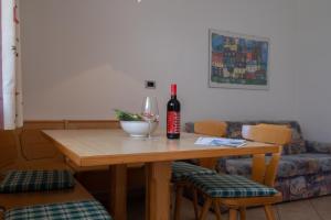 a table with a bottle of wine and a glass at Rabland Haus Texel I in Rablà