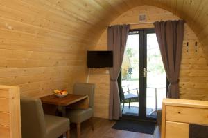 a room with a wooden wall with a table and a television at Kleine Nordseewelle ohne Hund in Norden