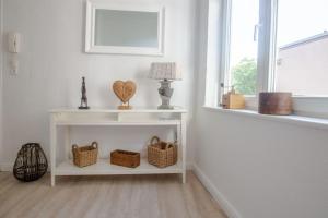 a room with a white table with baskets and a window at Apartment No4 in Stralsund