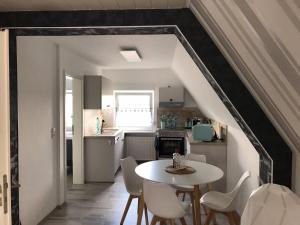 a kitchen and dining room with a table and chairs at Ferienwohnung mit Seeblick in Jemgum
