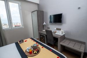 a small room with a table and a desk and a room with a bed at Le Louvre Hotel & Spa in Antananarivo