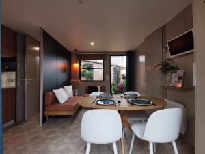 a living room with a table and white chairs at Ostseeferienpark Walkyrien - Bootsmann 10 in Schashagen