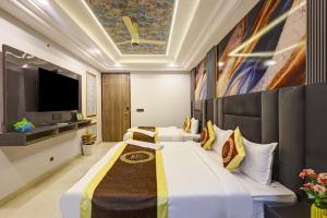 a hotel room with two beds and a flat screen tv at Hotel Armani Suites-Free Airport Drop in New Delhi +28 photos