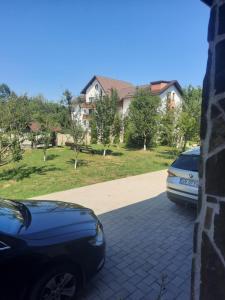 zwei Autos, die in der Einfahrt eines Hauses geparkt sind in der Unterkunft Pensiunea Daiana in Frasin