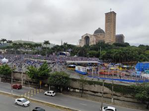 a large crowd of people are gathered in a parking lot at Pousada São Miguel Arcanjo in Aparecida