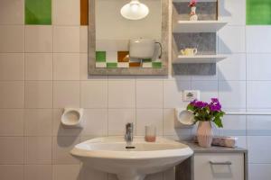 un bagno con un lavandino e un vaso di fiori di Ferienhaus Casa Limone - Villaggio Galanu a Costa Paradiso