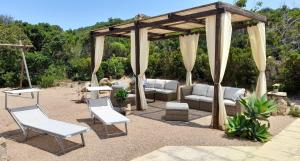 un gazebo con divano e sedie sotto di Ferienhaus Casa Limone - Villaggio Galanu a Costa Paradiso