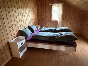 a bed in a wooden room with a window at Stort hus på Fen i Ulefoss i rolige omgivelser in Ulefoss