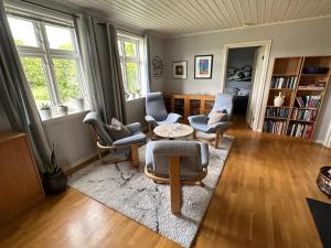 a living room with chairs and a table at Stort hus på Fen i Ulefoss i rolige omgivelser in Ulefoss