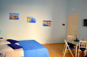 una camera da letto con un letto e un tavolo e quadri appesi al muro di Solemare Musica & Poesia a Napoli