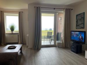 a living room with a couch and a flat screen tv at Apartment 10 in Wilhelmshaven
