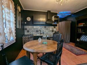 キュエールにあるLa maison sur demandeの部屋に木製のテーブルと椅子が置かれたキッチン